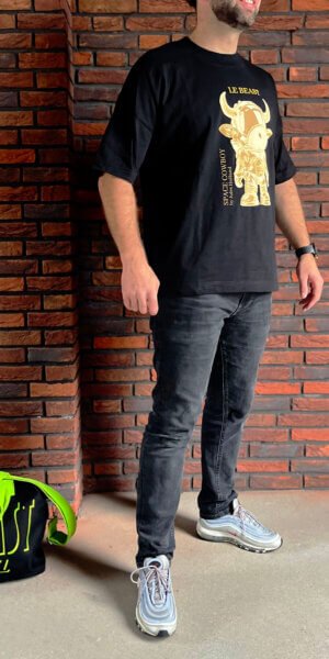 Man draagt zwarte SpaceCowboy T-shirt van Le Beast Label, duurzaam en GOTS-gecertificeerd, met artistieke print van de Space Cowboy by Jules Holland, Limited streetwear Collectie