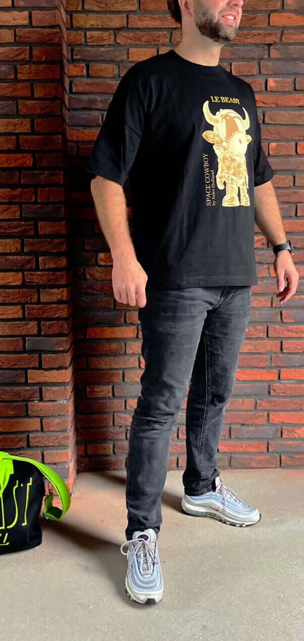 Man draagt zwarte SpaceCowboy T-shirt van Le Beast Label, duurzaam en GOTS-gecertificeerd, met artistieke print van de Space Cowboy by Jules Holland, Limited streetwear Collectie